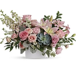 Pink roses and lilies arranged in a white rectangular vase