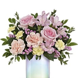 Pink and peach flowers arranged in an iridescent glass vase