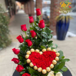 Red roses and a heart-shaped flower arrangement with gold chocolates