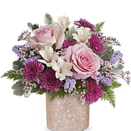 Pink roses and purple flowers arranged in a glittery vase