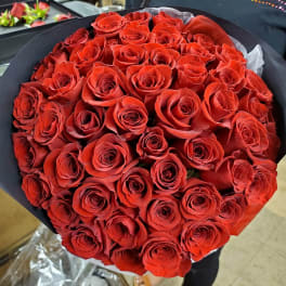 Large bouquet of red roses wrapped in black paper