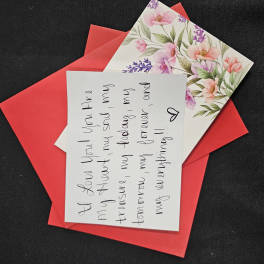 Red envelope with a floral card and handwritten note