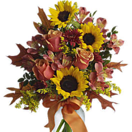 Bouquet of sunflowers, roses, and alstroemeria in a glass vase