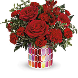 Red roses and carnations in a colorful mosaic vase