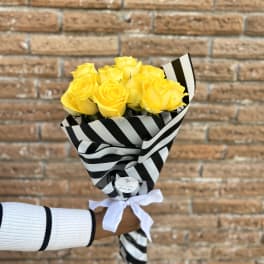 Bouquet of yellow roses wrapped in black-and-white striped paper