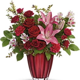 Red roses and pink lilies arranged in a red vase