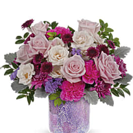 Pink and white rose bouquet in a purple glass vase