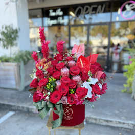 Red rose arrangement in a velvet box with a ribbon bow