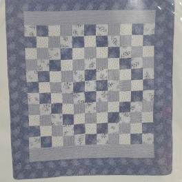Blue and white patchwork quilt with a floral checkerboard pattern