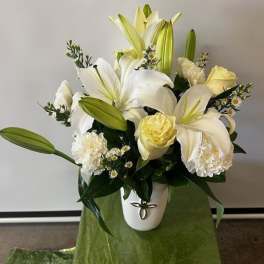 White lilies and pale yellow roses in a white vase