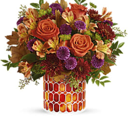 Autumn bouquet of orange roses and purple flowers in a mosaic vase