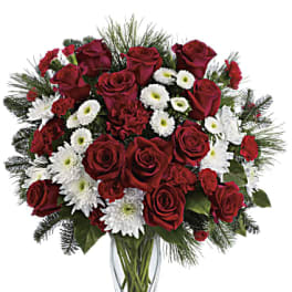 Red roses and white daisies in a clear glass vase