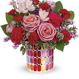 Pink roses and red carnations in a colorful mosaic vase