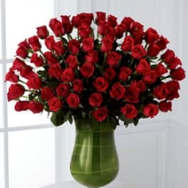 Large bouquet of red roses in a green glass vase