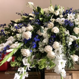 Large white and blue floral spray with roses and lilies