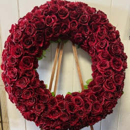 Large circular wreath of red roses on a wooden easel