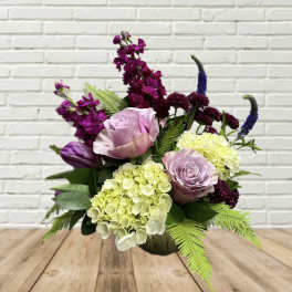 Mixed bouquet with lavender roses, hydrangeas, and purple blooms in a vase