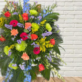 Large mixed floral spray with roses, gerbera daisies, and blue delphinium
