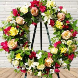 Floral wreath with roses and mixed blooms on a stand