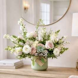 Pastel bouquet of roses and white blooms in a green vase