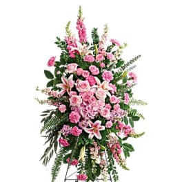 Pink floral standing spray on an easel with lilies and roses