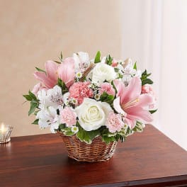 Pink and white flower arrangement in a wicker basket