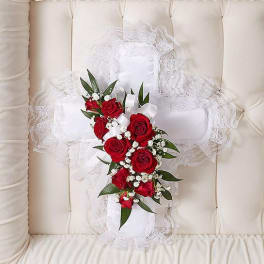 White lace pillow with a red rose bouquet and ribbon