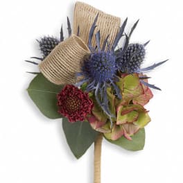 Boutonniere with blue thistle, burgundy bloom, and burlap wrap