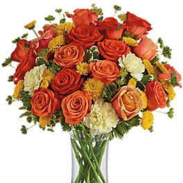 Bouquet of orange and red roses with yellow accents in a clear glass vase