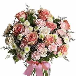 Pink and white rose bouquet in a clear glass vase with a pink ribbon