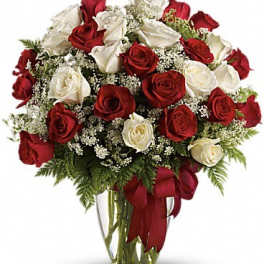 Red and white roses arranged in a clear glass vase