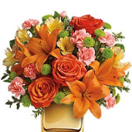 Orange and pink flower arrangement in a square glass vase