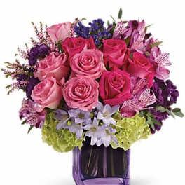Pink and purple rose bouquet in a purple glass vase