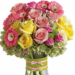 Pink and yellow roses with pink gerbera daisies in a glass vase