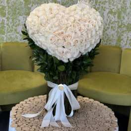 Heart-shaped bouquet of white roses with a white ribbon