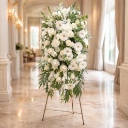Tall white floral standing spray on a metal easel