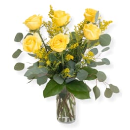 Yellow roses in a clear glass vase with airy filler flowers