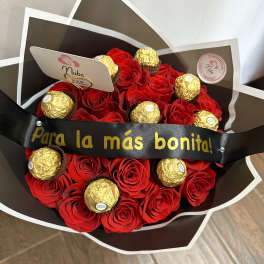 Bouquet of red roses with gold-wrapped chocolates and a black ribbon