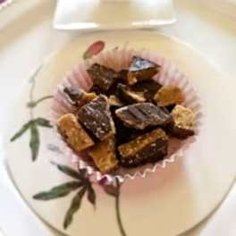 Chocolate pieces in a pink paper cup on a decorative plate