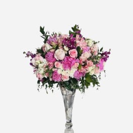 Pink and white floral arrangement in a tall clear glass vase