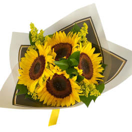 Bouquet of sunflowers wrapped in paper with a yellow ribbon