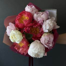 Hand-tied bouquet of pink and white peonies wrapped in paper