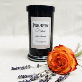 Black candle jar with an orange rose and lavender sprigs