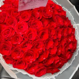 Large bouquet of red roses wrapped in white paper