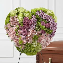 Heart-shaped floral spray with pink and purple flowers on a stand