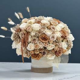 Bouquet of cream and beige roses in a round vase