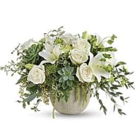 White roses and lilies in a round ceramic vase with succulents