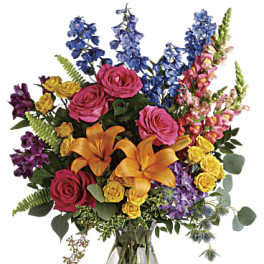 Colorful bouquet of roses, lilies, and snapdragons in a glass vase