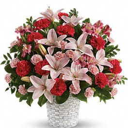 Pink lilies and red carnations in a woven basket vase