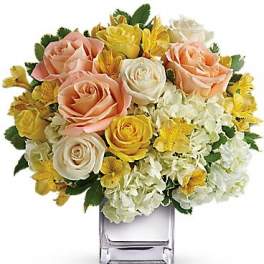 Bouquet of pink, yellow, and white roses in a clear glass vase